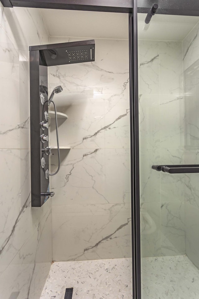 full bathroom with a marble finish shower