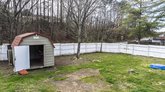 view of yard featuring a storage shed, a fenced backyard, and an outdoor structure