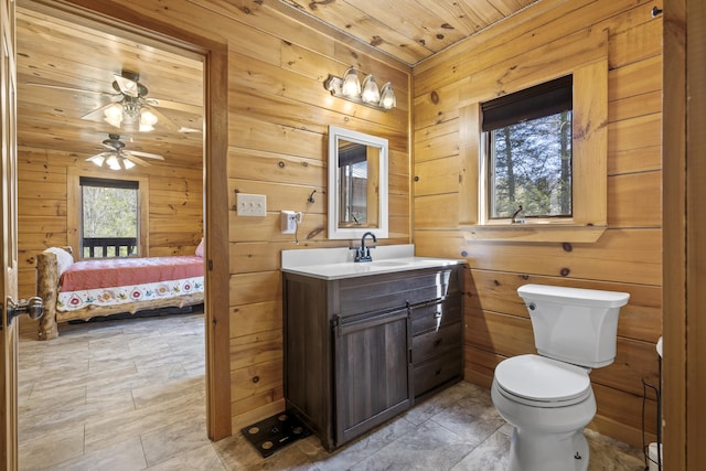 ensuite bathroom with wooden walls, wooden ceiling, and toilet