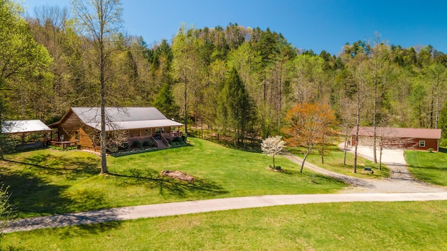 view of home's community with a yard and a wooded view