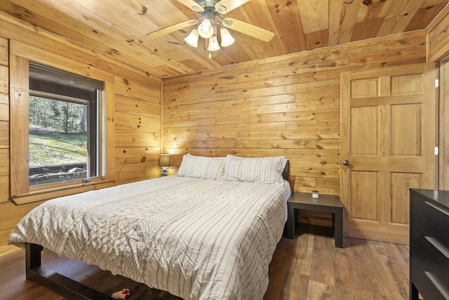 bedroom featuring wooden ceiling, a ceiling fan, wood walls, and wood finished floors