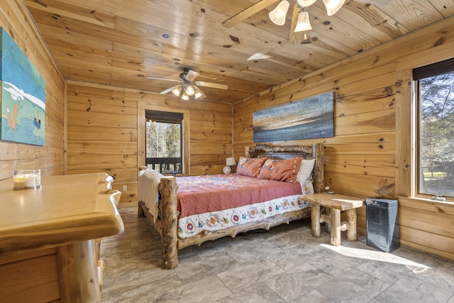 bedroom featuring a ceiling fan, wooden walls, multiple windows, and wooden ceiling