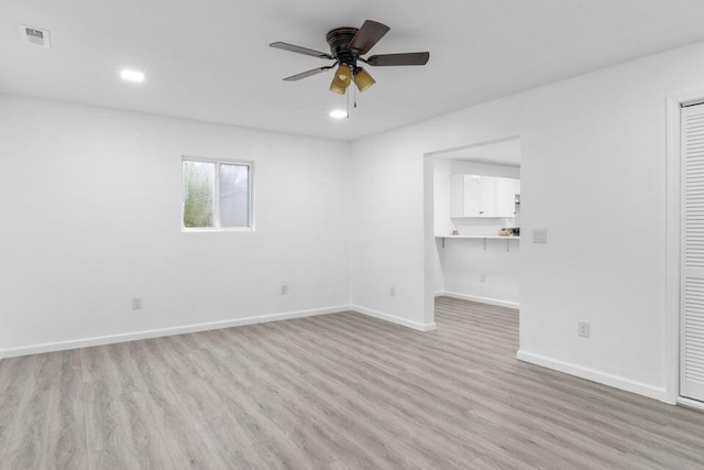 spare room with ceiling fan and light wood-type flooring