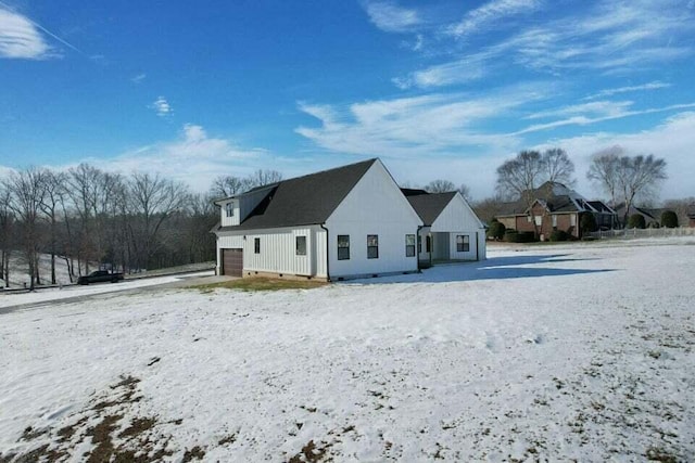 snow covered property featuring a garage