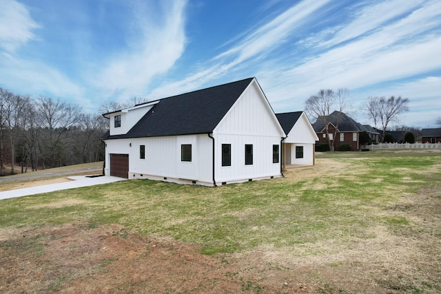 view of home's exterior featuring a garage, concrete driveway, a lawn, and roof with shingles