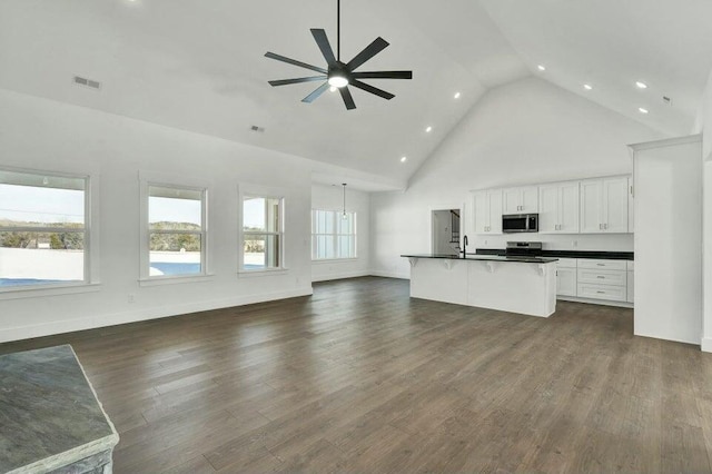 kitchen featuring white cabinetry, a healthy amount of sunlight, an island with sink, and dark hardwood / wood-style flooring