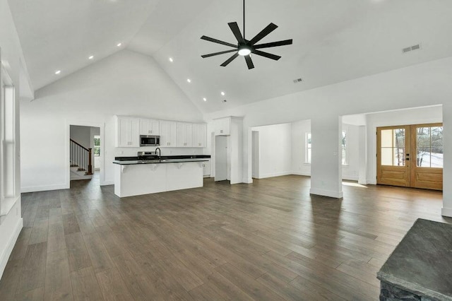 unfurnished living room featuring french doors, sink, high vaulted ceiling, dark hardwood / wood-style floors, and ceiling fan