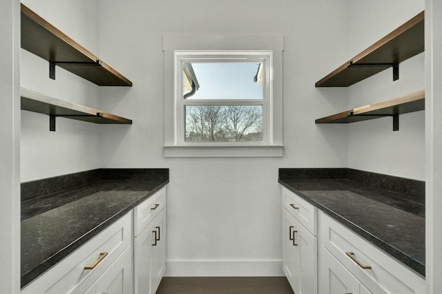 kitchen featuring white cabinetry, dark hardwood / wood-style floors, and dark stone countertops