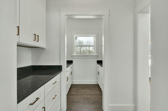 kitchen with white cabinetry, dark hardwood / wood-style flooring, and dark stone counters