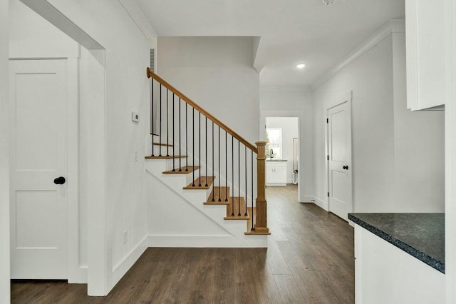 foyer with ornamental molding and dark hardwood / wood-style floors