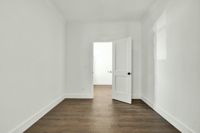 empty room with dark wood-type flooring and ornamental molding