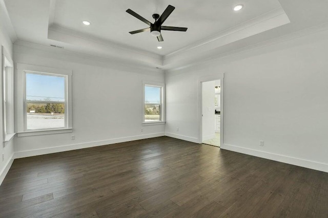 unfurnished room with dark hardwood / wood-style floors, a tray ceiling, and crown molding