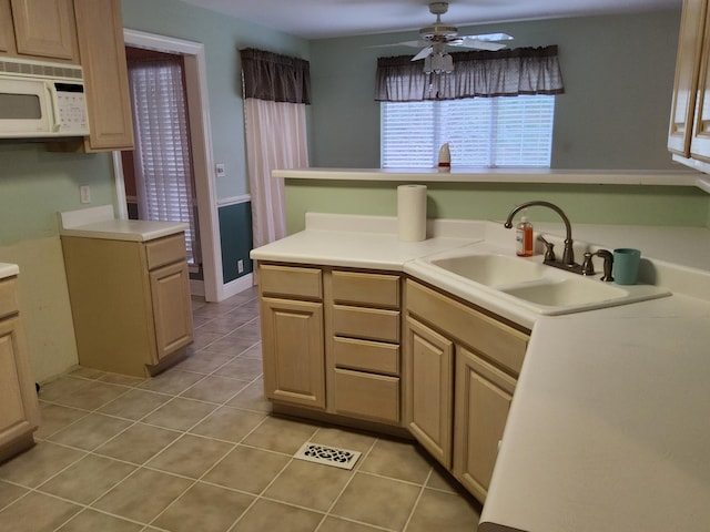 kitchen with light brown cabinets, sink, ceiling fan, light tile patterned floors, and kitchen peninsula