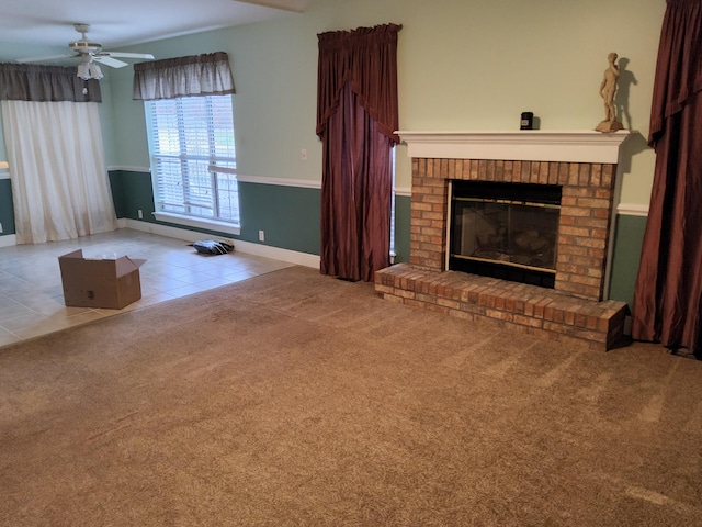 unfurnished living room featuring a fireplace, ceiling fan, and light tile patterned flooring