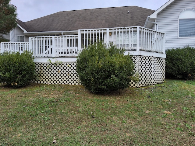 rear view of house featuring a deck and a yard