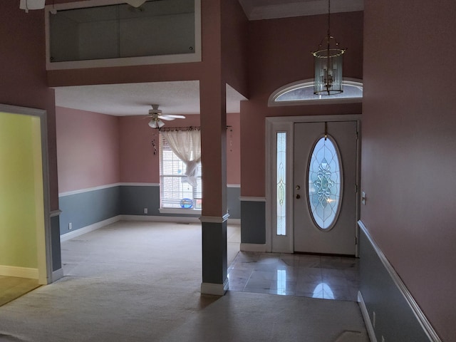 carpeted foyer featuring ceiling fan and a textured ceiling