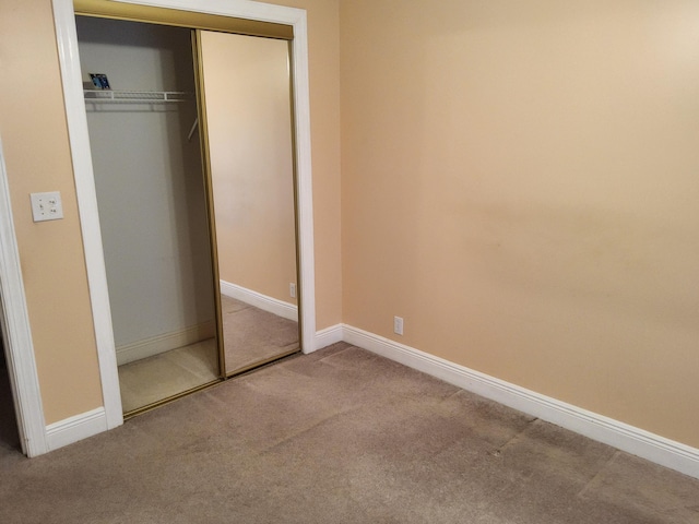 unfurnished bedroom with a closet and carpet floors