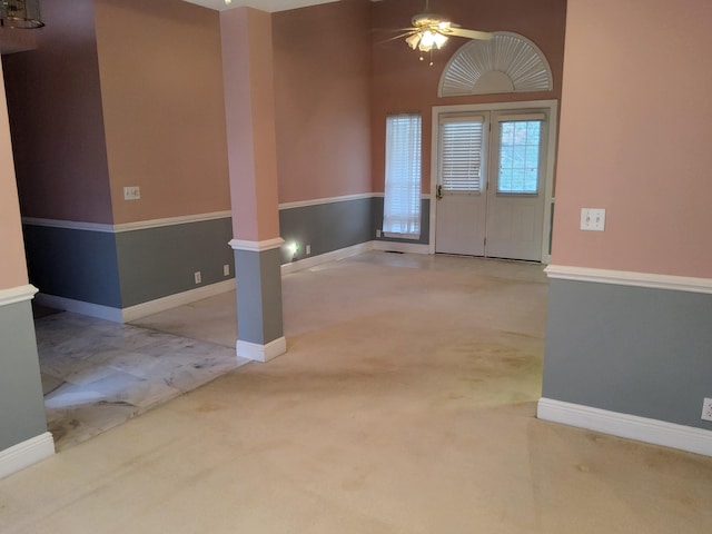 foyer entrance featuring light carpet, a towering ceiling, and ceiling fan