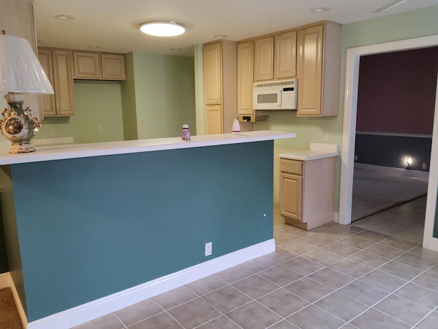 kitchen featuring light tile patterned flooring, kitchen peninsula, and light brown cabinets