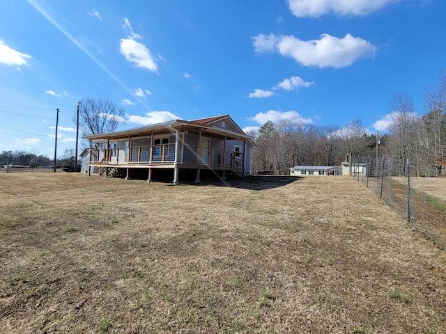 rear view of property with a wooden deck and a yard