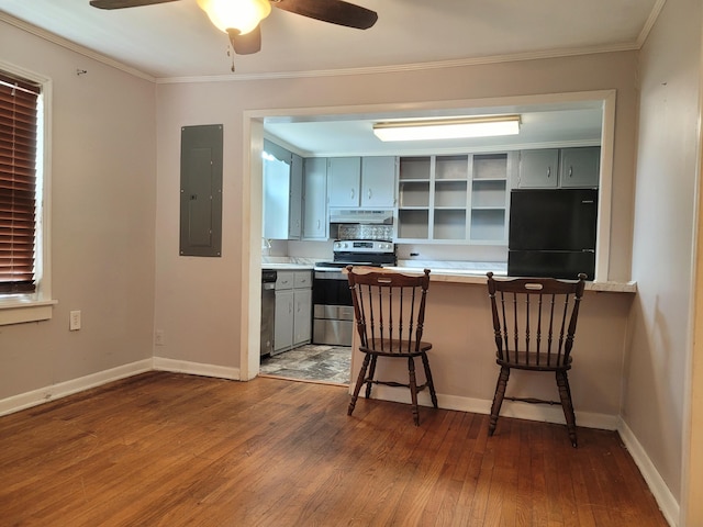 kitchen with appliances with stainless steel finishes, a kitchen bar, electric panel, and gray cabinetry