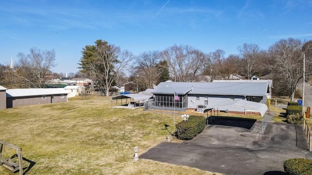 view of yard featuring a carport and a sunroom