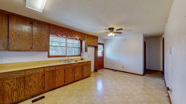 kitchen with ceiling fan, sink, and a textured ceiling