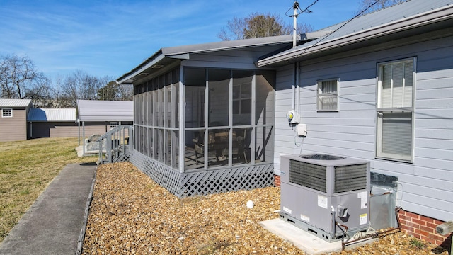 view of side of property featuring central AC, a carport, and a sunroom