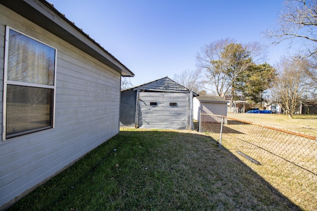 view of side of home with a garage, a yard, and an outdoor structure