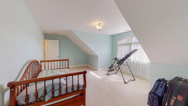 carpeted bedroom with baseboards and vaulted ceiling