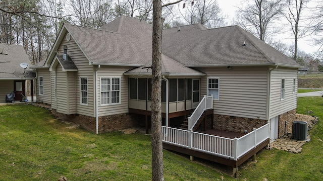 back of house with central air condition unit, roof with shingles, a yard, and a sunroom