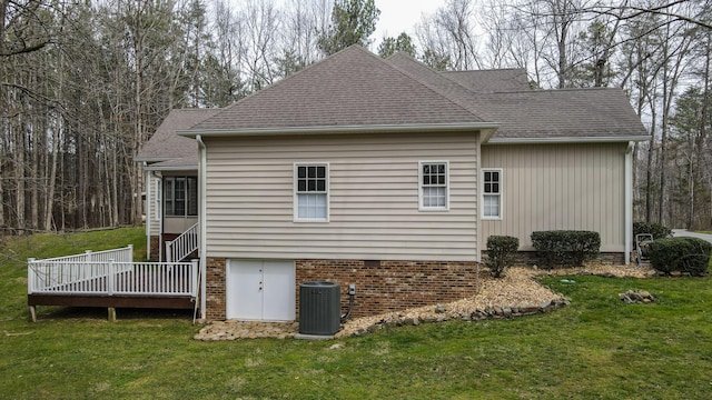 back of house with cooling unit, a yard, a deck, and a shingled roof