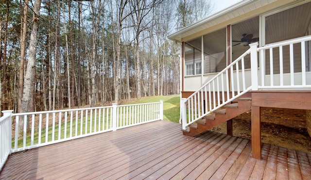 wooden deck with a lawn, stairs, and a sunroom