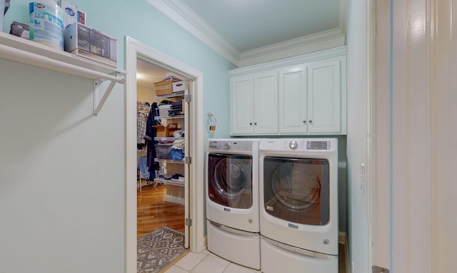 laundry area with crown molding, light tile patterned floors, cabinet space, and independent washer and dryer