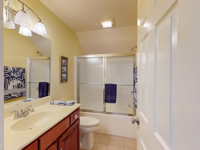 bathroom featuring tile patterned floors, enclosed tub / shower combo, toilet, and vanity