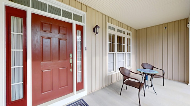 entrance to property with board and batten siding and a porch