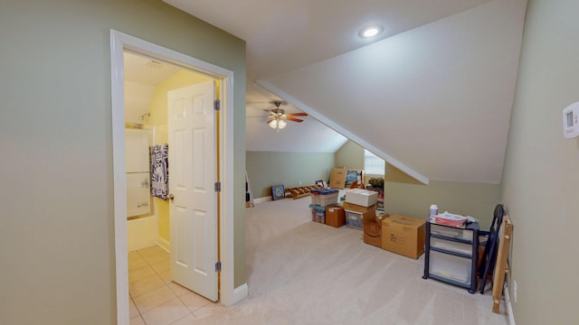 bonus room featuring baseboards, carpet, lofted ceiling, tile patterned floors, and a ceiling fan