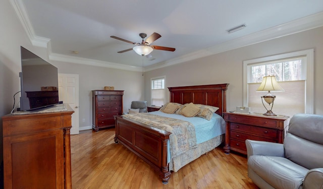 bedroom featuring visible vents, light wood-style flooring, crown molding, baseboards, and ceiling fan