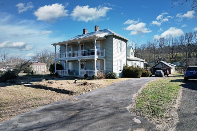 view of front of property with a balcony, a garage, and covered porch