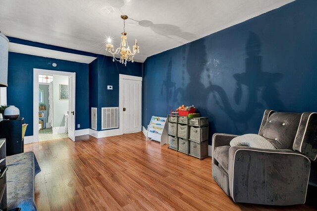 sitting room featuring hardwood / wood-style floors and a chandelier