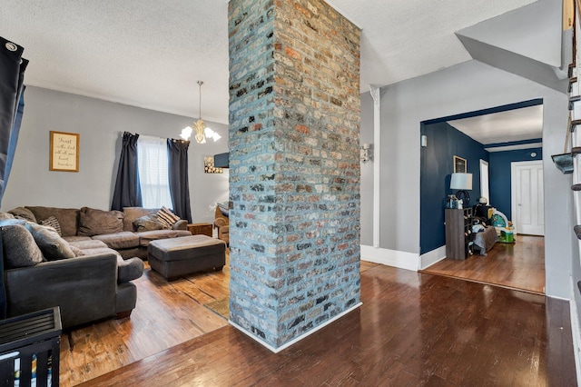 living room featuring wood-type flooring, a textured ceiling, lofted ceiling, and a notable chandelier