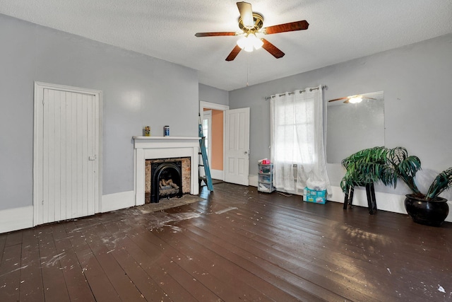 unfurnished living room with ceiling fan, dark wood-type flooring, and a textured ceiling