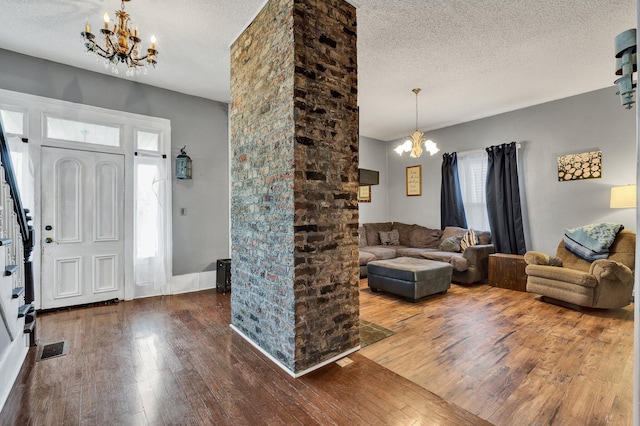 entrance foyer with a notable chandelier, hardwood / wood-style floors, and a textured ceiling