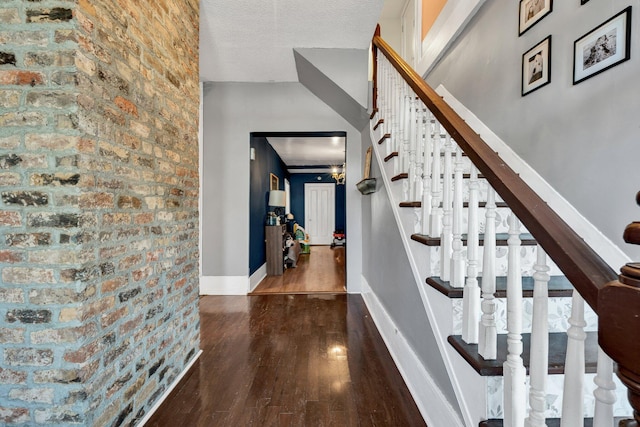 stairs with hardwood / wood-style floors and a textured ceiling