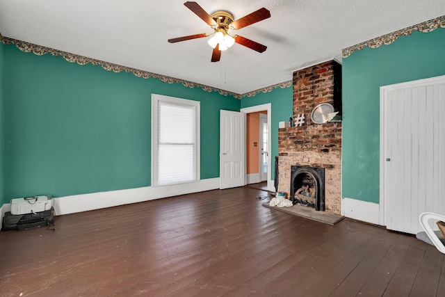 unfurnished living room featuring a fireplace, a textured ceiling, ceiling fan, and dark hardwood / wood-style flooring