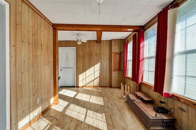 interior space featuring light hardwood / wood-style floors, beamed ceiling, and a healthy amount of sunlight