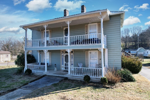 view of property featuring a balcony and covered porch