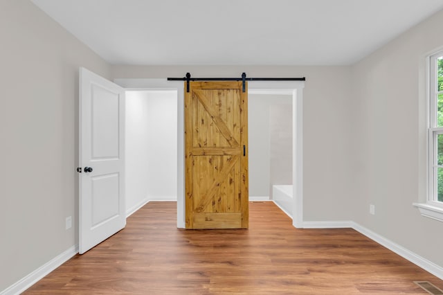 1050 King Edward Ave SE, Cleveland, TN 37311 - unfurnished bedroom featuring wood finished floors and a barn door