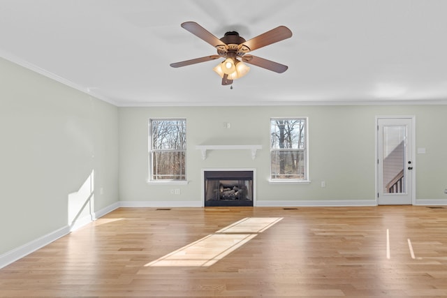 unfurnished living room with a healthy amount of sunlight, ornamental molding, and light hardwood / wood-style flooring