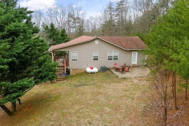 rear view of property featuring central AC, a yard, and a patio